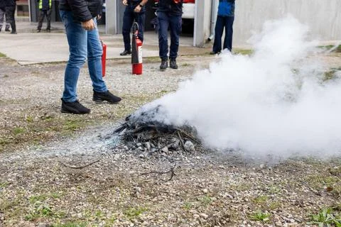 Smoke rises from a recently extinguished fire on gravel Foto stock