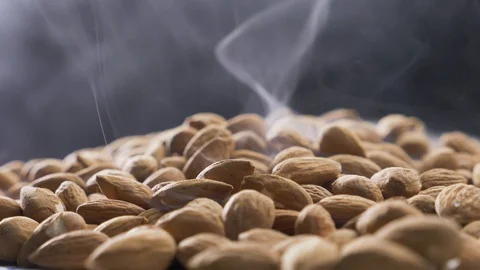Smoke rises through almonds which spin on a black background Stock-Footage 118470081