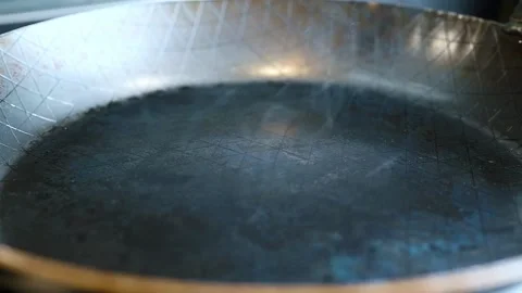 Smoke rises from a very hot rustic steak steel pan being fried on the kitch.. Vidéo 227772540