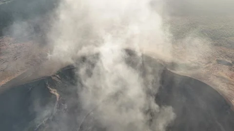 Smoke rising from an active volcano in the early morning light Video stock 332619931