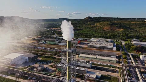 Smoke rising from a factory stack in an industrial area during the day 動画素材 341329707