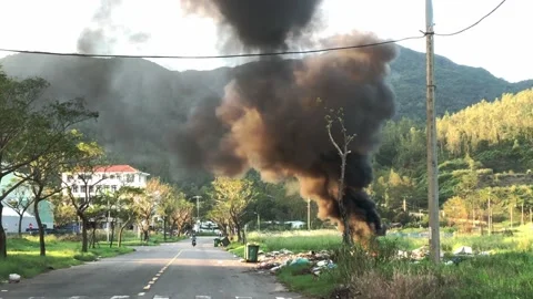 Smoke rising from a fire in a dumping site by the street Video stock 143623083
