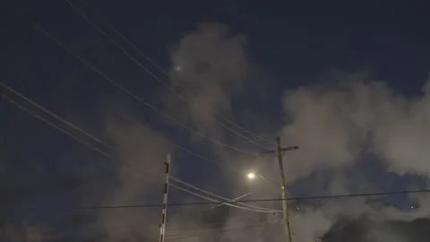 Smoke rising in front of street light and power lines Stock Footage 225408359