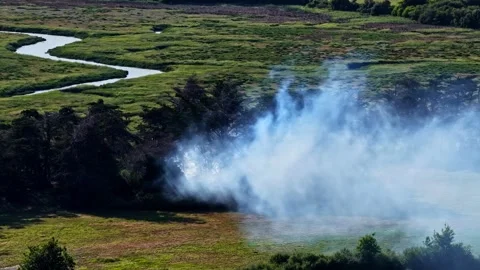 Smoke rising over winding river and green marshland near Nantes France Stock Footage 346581599