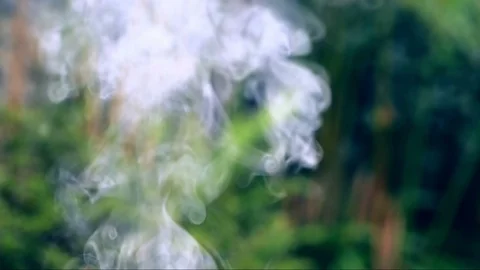 Smoke rising in swirls with bokeh background Stock Footage