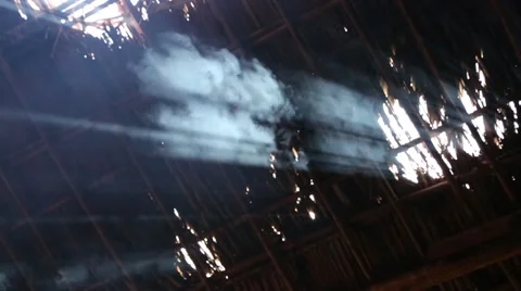 Smoke rising through gaps in grass roof 動画素材 42150955