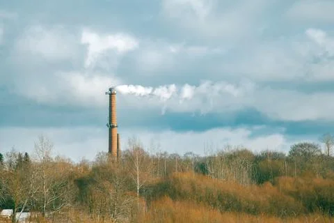 Smoke Stack with Blue Sky and Green Trees Stock Photos