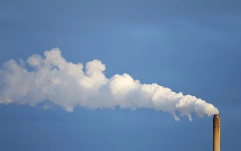 Smoke stack spewing white smoke to blue sky , Finland Stock Photos