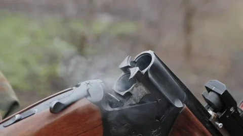 Smoke from trunks of smooth-bore hunting rifle after firing.Takes out cartridges 스톡 동영상 84419678