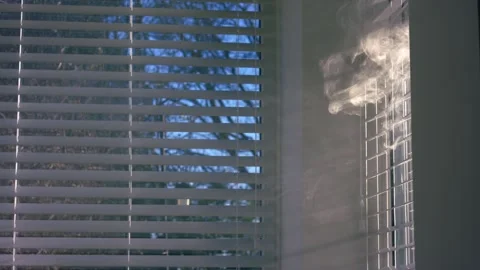 Smoke in window blinds slats in sunlight Vídeos de archivo 331247373