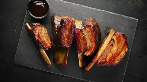 Smoked beef ribs with bone on a black background. Stock Footage 150509341