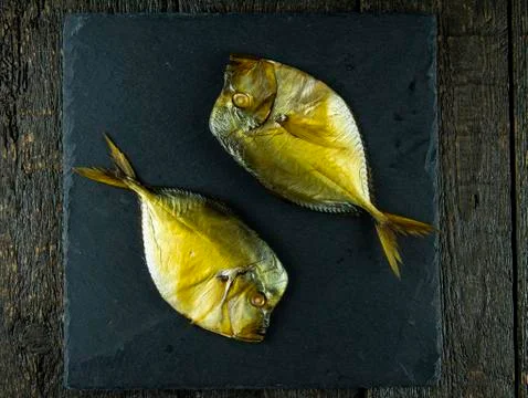 Smoked fish on stone background. Stock Photos