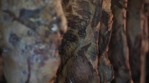 Smoked ham hangs in the dark attic Stock Footage 129197281
