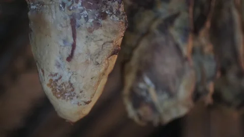 Smoked ham hangs in the dark attic Stock Footage 129198138