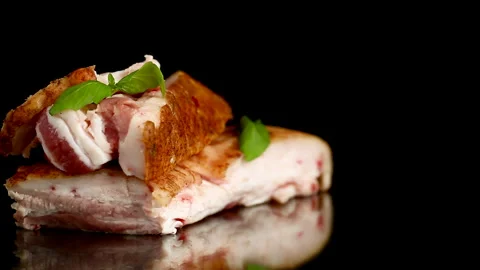 Smoked pork lard with aromatic basil on elegant black reflective background Stock Footage 340416181