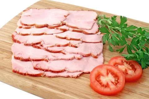 Smoked slices of ham on wooden cutting board Stock Photos