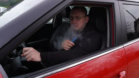 Smokes while driving a car Stock Photos