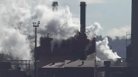 Smokestacks and carbon emissions into the environment from heavy industry 库存影片 149890650