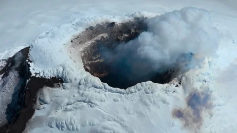 Smoking active volcano crater covered with snow and ice Stock Footage 335498641