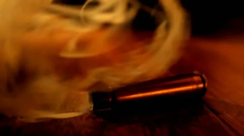 Smoking Bullet on Table Video HD Stock Footage 22149702