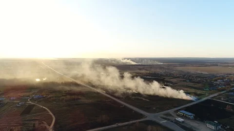 Smoking Burning Grass on the Side of the Road next to a Plowed Field. Firefighte Stock Footage 128928874