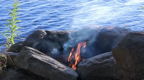 Smoking campfire by a lake Stock Footage 55100664