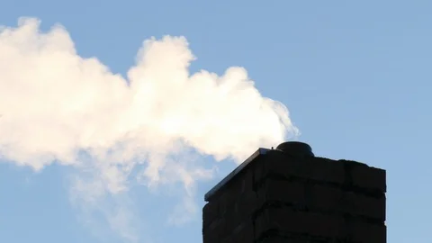 Smoking chimney made of brick, back light, shadow, blue sky Stock Footage 124407805
