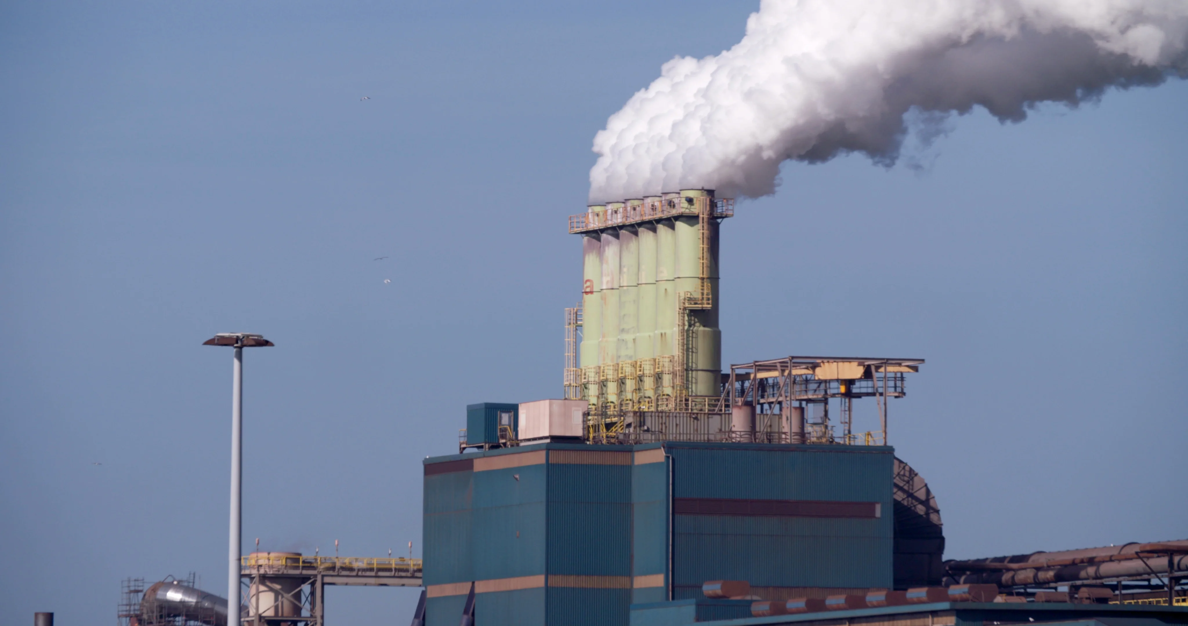 Factory Tata Steel with smoking chimneys on a sunny day, IJmuiden, The  Netherlands Stock Photo