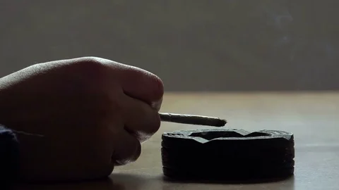 Smoking a cigarette hand throwing ashes in the ashtray on the table Stock-Footage 74413341