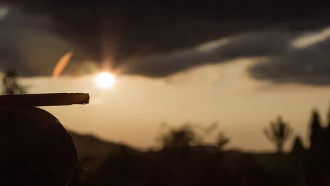 Smoking cigarette with sunset in background timelapse Stockbeeldmateriaal 93691210
