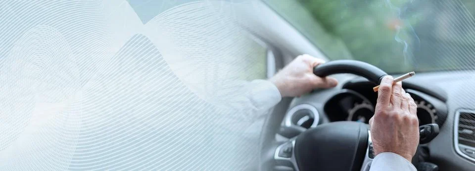 Smoking a cigarette while driving; panoramic banner Foto stock