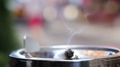 Smoking cigarette. White filter in an iron ashtray in the cafe. Crowd  5 Stock Footage 77998048