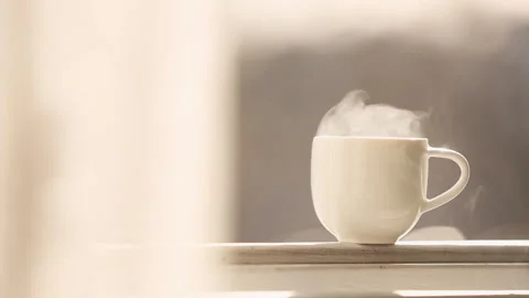 A smoking Cup of hot tea at window side abstract blur background. Stock Footage 87602037