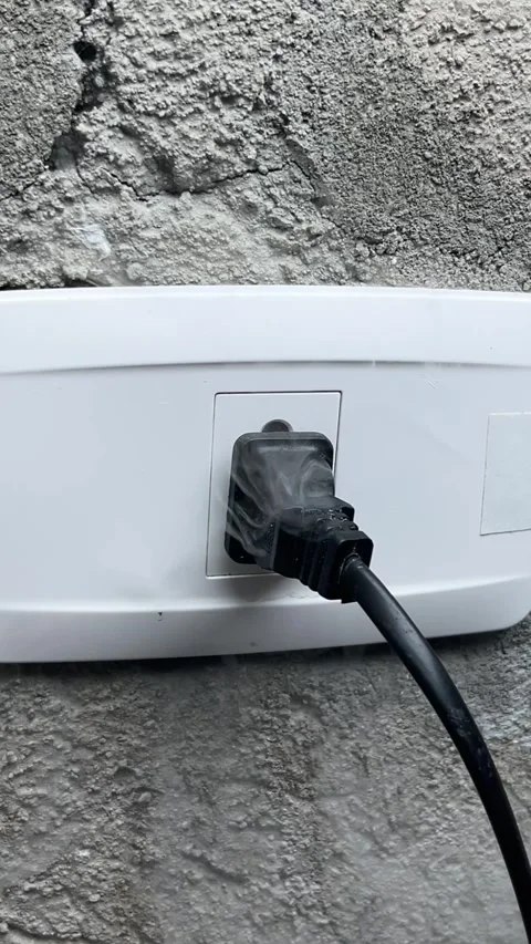 A smoking electrical outlet, a hand pulling the plug out of a burning outlet Stock Footage 317733503