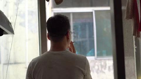 Smoking in front of the window and thinking about life Stock Footage 139814439
