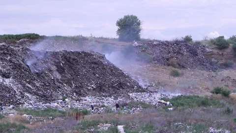Smoking garbage on landfill.  Two poor people searching useful things. Stock Footage 111577508