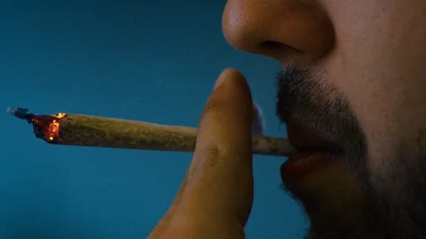 Smoking a hand-rolled long cigarette - Slowmo 100fps Stock Footage 87807995