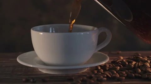 Smoking hot coffee with coffee beans on wooden table Stock Footage 65794786