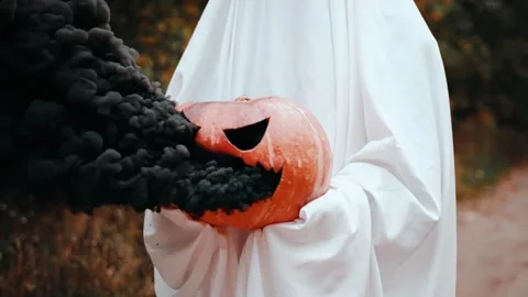 Smoking Jack O Lantern in the hands of a ghost in the forest Stock Footage 252418787