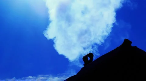 Smoking old chimney on the backdrop of clear blue sky 库存影片 1046115