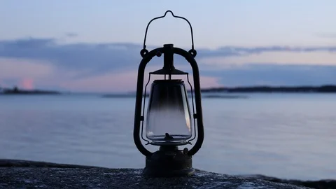 A smoking old rusty kerosene lamp on a rock Stock Footage 126836632