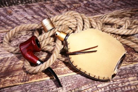 Smoking pipe and eau de cologne. Men's recreation accessories on wooden table. Stock Photos
