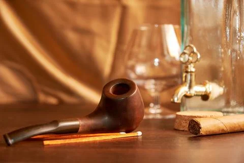 Smoking pipe with matches, empty wine bottle, and glass Stock Photos