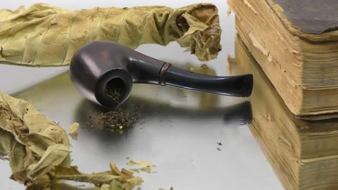 A smoking pipe in the smoke next to an old book. Stock Footage 133445798