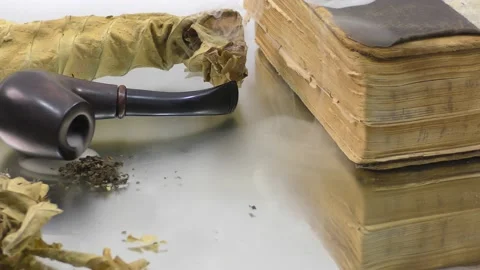 A smoking pipe in the smoke next to an old book. Stock Footage 133445815