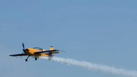 Smoking propeller plane scrolls in the sky, flying at an air show, making a loop Stock Footage 120002137