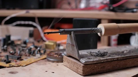 Smoking Soldering Iron on Cluttered Electronics Workbench Pan Left Stock Footage 306045690