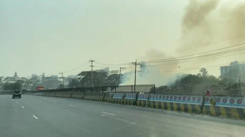 Smoking trash fire POV windshield view driving along India highway Stock Footage 346189618