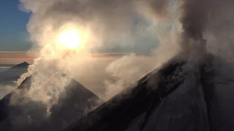 Smoking volcano erupting ash during sunrise Stock Footage 337034104