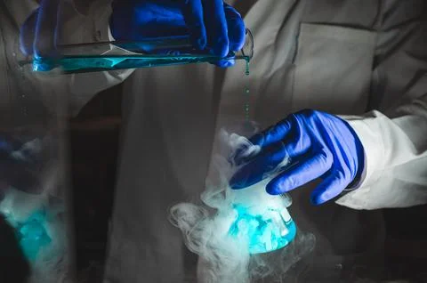 Smoky experiments with blue colour solution.  Scientist working on chemical.. Foto stock